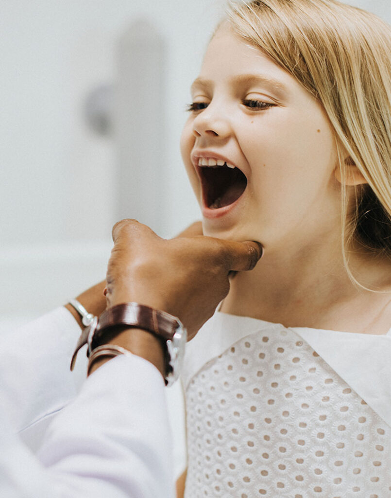 dentist inspecting a childs teeth